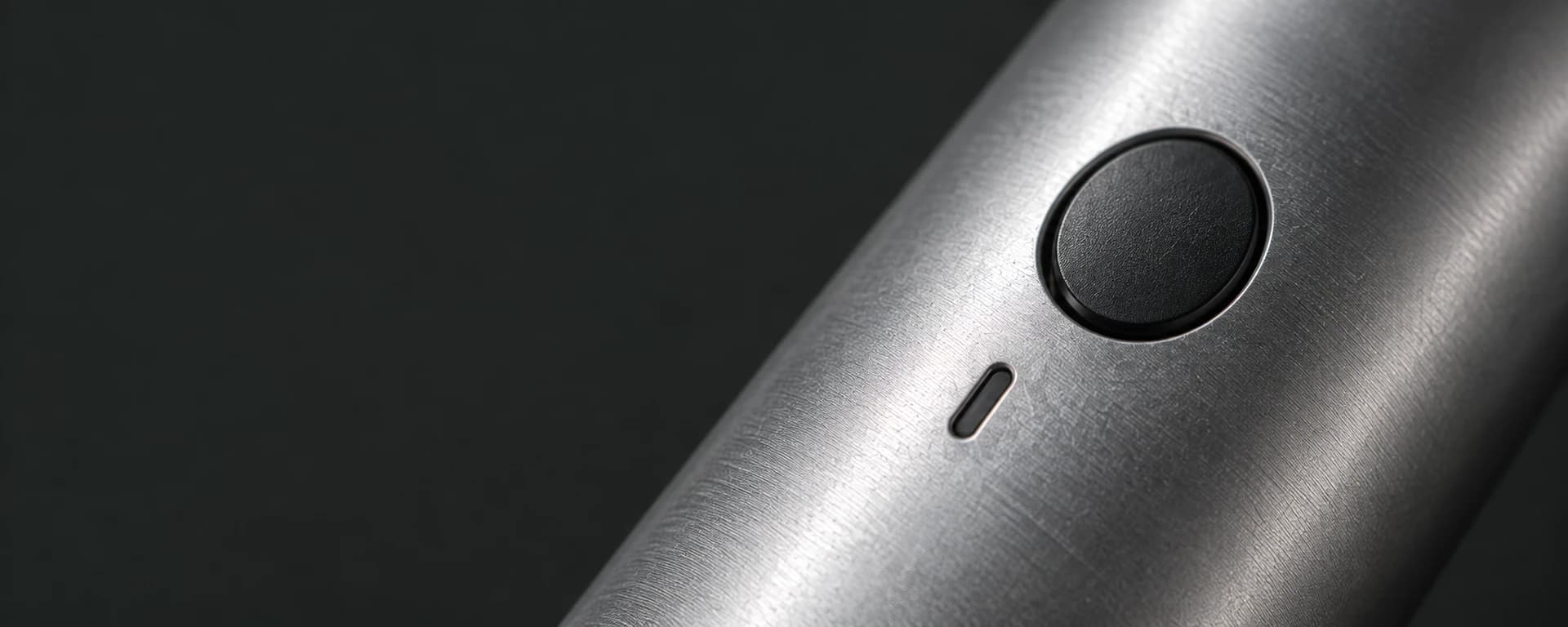 Concept detail of a black control button on a brushed metal exterior